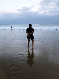 Rear view of man standing on beach