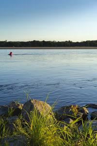 Scenic view of lake against clear blue sky