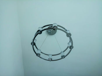 Low angle view of circular lighting equipment on ceiling