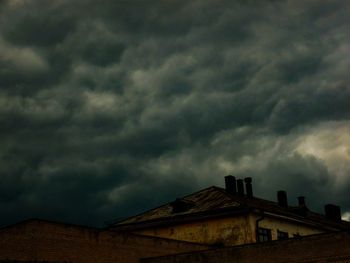 Low angle view of house against dramatic sky