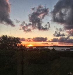 Scenic view of sea against cloudy sky during sunset