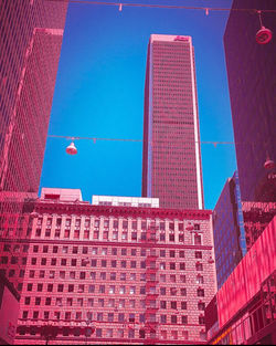 Low angle view of modern buildings against clear blue sky