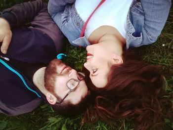 Portrait of smiling young couple lying on grass