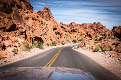 Road amidst rock formation against sky