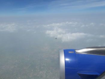Close-up of airplane wing over sea against sky