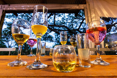 Wine-tasting in rustic ambience multiple glasses and colorful liquids set up on wooden table