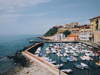 High angle view of boats moored at harbor by buildings