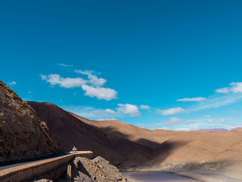 Scenic view of mountains against blue sky