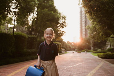 Portrait of smiling boy standing against trees