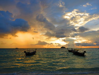 Boat in sea against sky during sunset