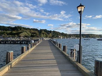 Northport village dock with a lamp post by the sea and ocean in northport harbor bay. 