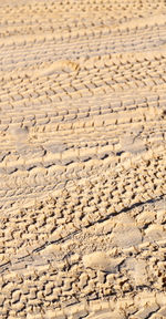 Full frame shot of tire tracks on sand