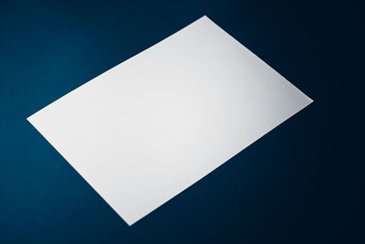 High angle view of white paper against blue background