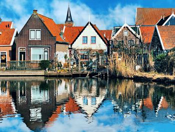 Reflection of buildings on river against sky