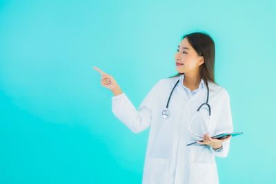 Woman standing against blue background