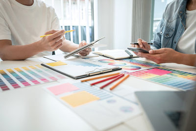 Midsection of business colleagues working on table