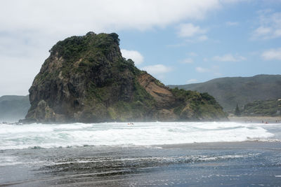 Rock formation on beach against sky