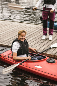 Portrait of smiling senior man sitting in kayak during kayaking course