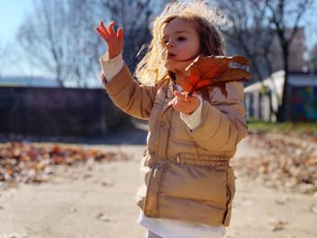 Girl holding umbrella while standing on land