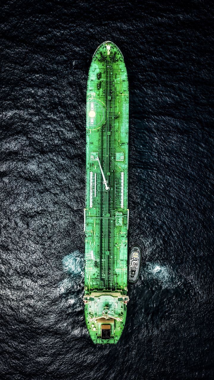 HIGH ANGLE VIEW OF ILLUMINATED BOTTLE ON GREEN LIGHT