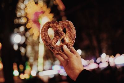 Close-up of hand holding ice cream cone at night