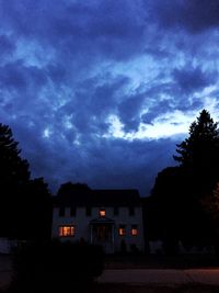 Silhouette houses against blue sky and clouds