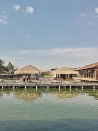 Buildings by lake against sky