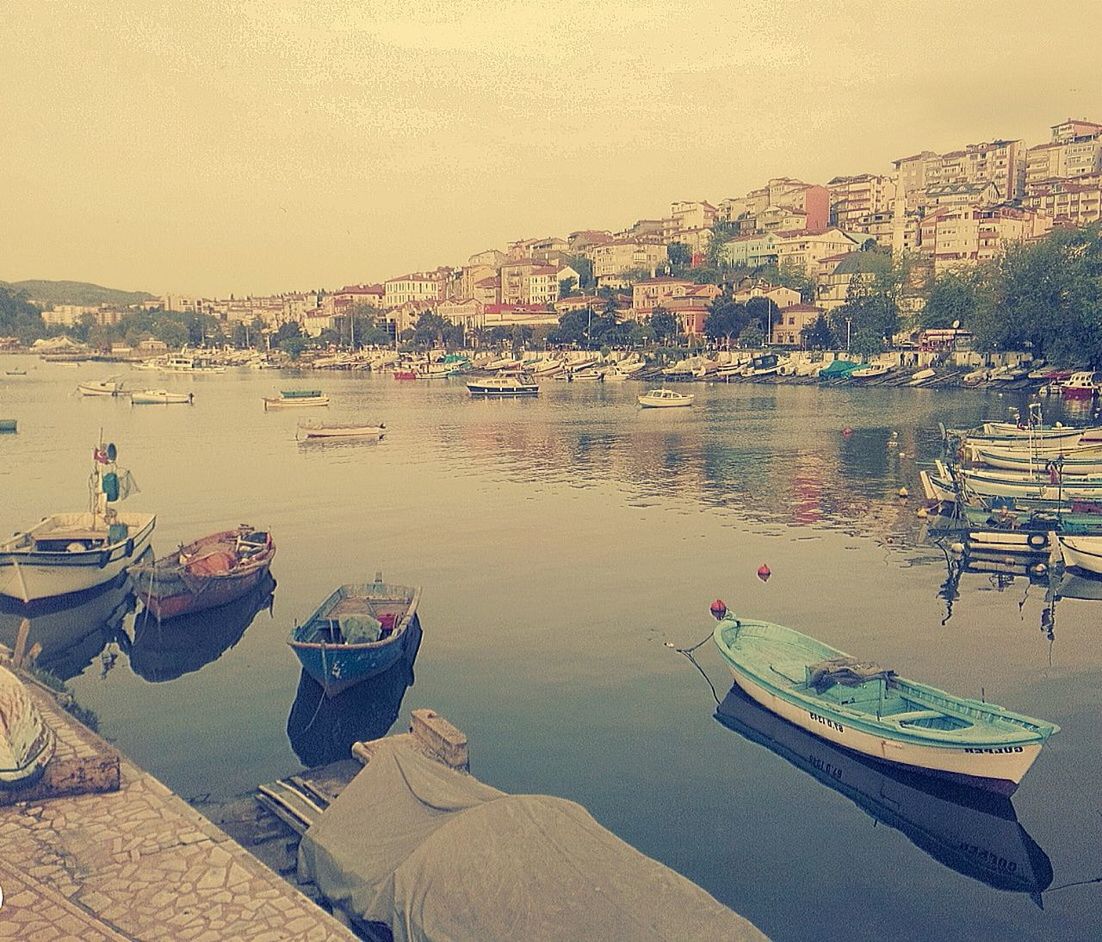 nautical vessel, water, boat, moored, transportation, mode of transport, building exterior, built structure, architecture, sea, high angle view, harbor, waterfront, clear sky, city, travel, river, outdoors, day, incidental people