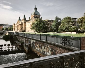 Bridge over river against buildings in city