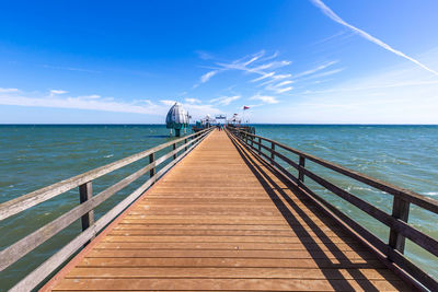 Pier over sea against blue sky