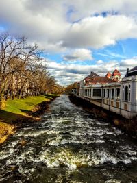 River amidst train against sky