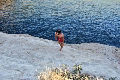 Rear view of man standing in sea