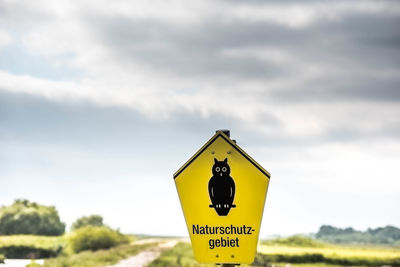 Information sign on road against sky