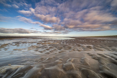 Scenic view of beach against sky during sunset