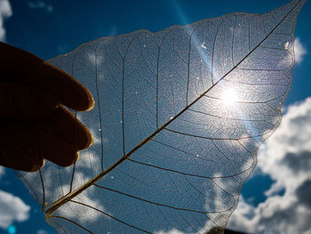 Low angle view of person hand against bright sun