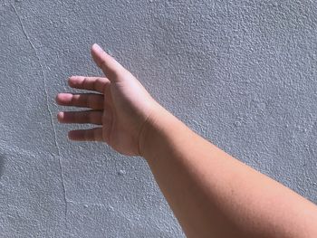 Close-up of person hand against wall