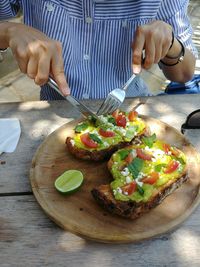 Midsection of woman eating food on table