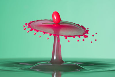 Close-up of water drops on red over white background