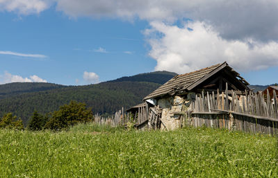 Old house on field against sky