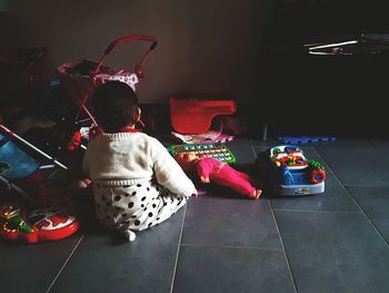 Rear view of girl sitting at home