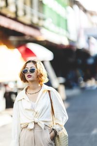 Woman wearing sunglasses standing on street