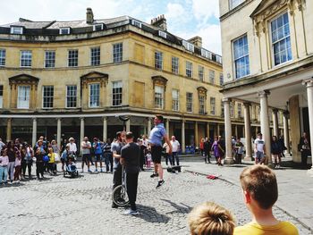 People on street against buildings in city