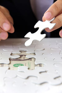 Midsection of businessman solving jigsaw puzzle
