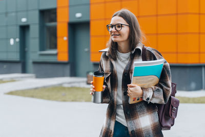 Portrait of smiling young woman standing outdoors