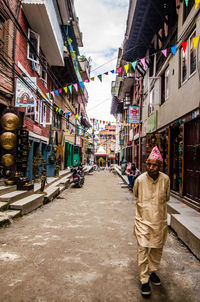 Man in city against sky