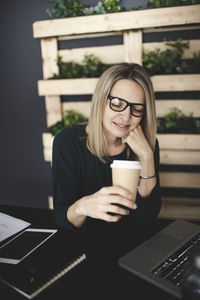 Woman holding coffee cup on table