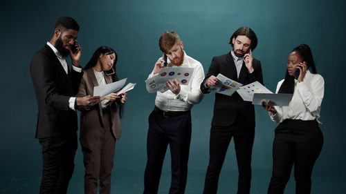 Business people brainstorming against blue background