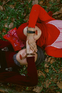 Directly above shot of female friends covering eyes with hands while lying down