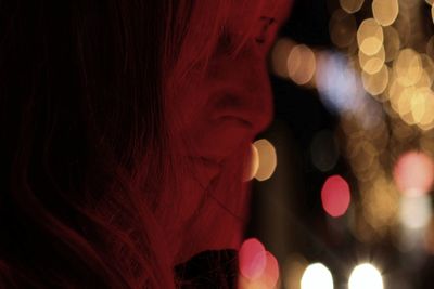 Close-up of woman looking at illuminated lights