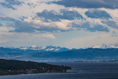 Scenic view of sea and mountains against sky